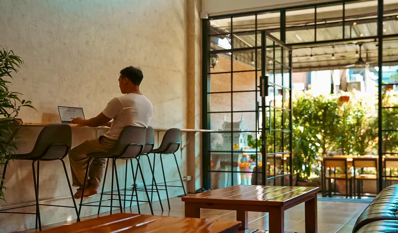 A lone traveler working at a desk at Stamps Hostel in Chiang Mai, Thailand