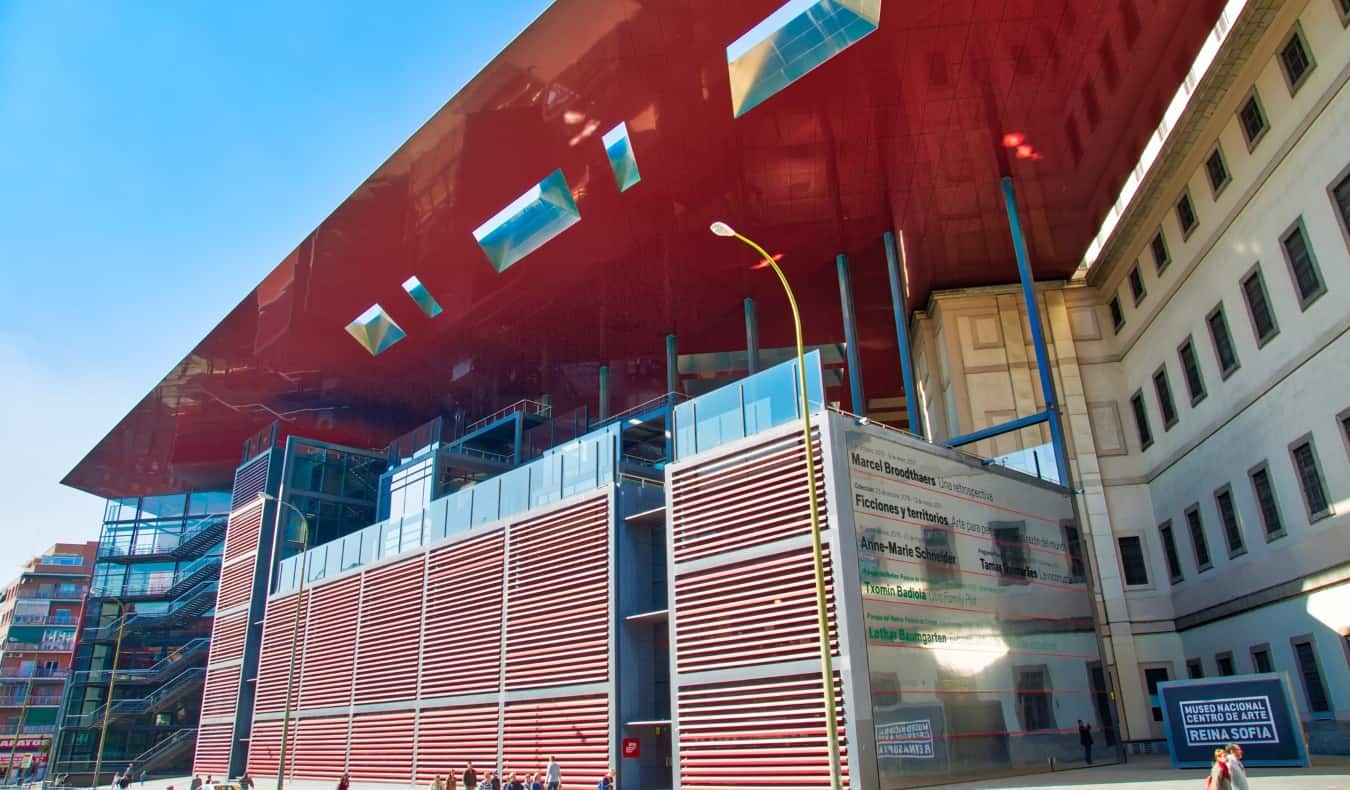 The exterior of the Reina Sofía Museum, with a bright red roof and a modern design, in Madrid, Spain