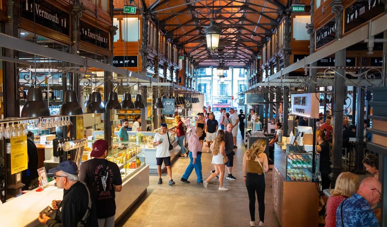 People walking down the aisles of the historic covered market, Mercado de San Miguel, in Madrid, Spain