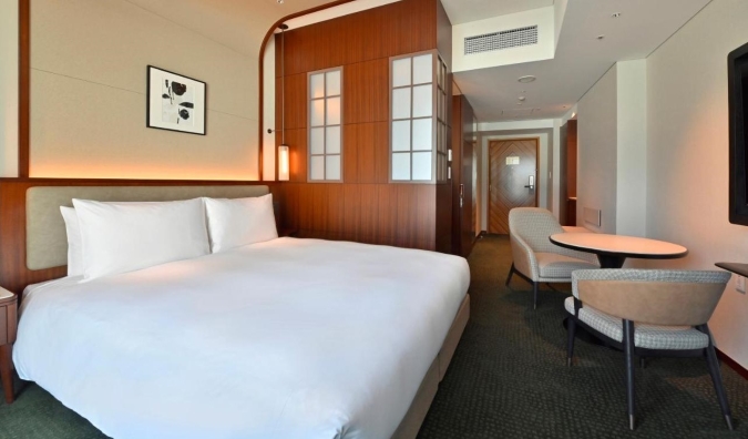 A double bed and small table with two chairs at a hotel in Tokyo, Japan