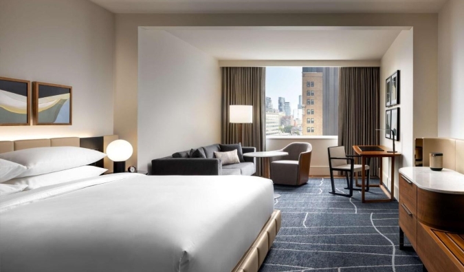 Spacious room with king-size bed, sofa, sitting area and large windows in minimalist contemporary design at Park Hyatt hotel in Toronto, Canada