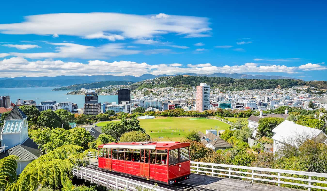 The red cable car ascending its track with the skyline of Wellington, New Zealand in the background