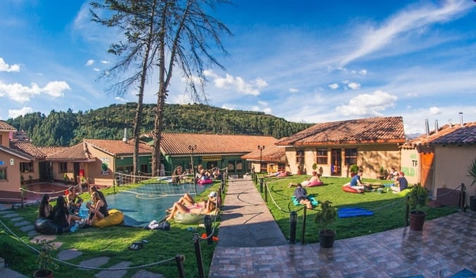 Vaste jardin avec des personnes jouant à des jeux de cour et se prélassant au Wild Rover, une auberge à Cusco, Pérou.