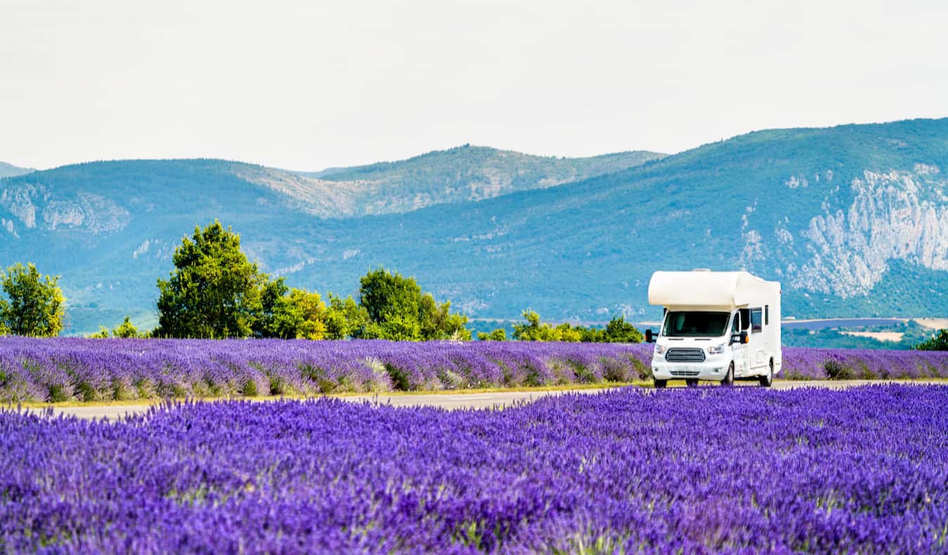 An RV parked driving in rural France on a sunny summer day