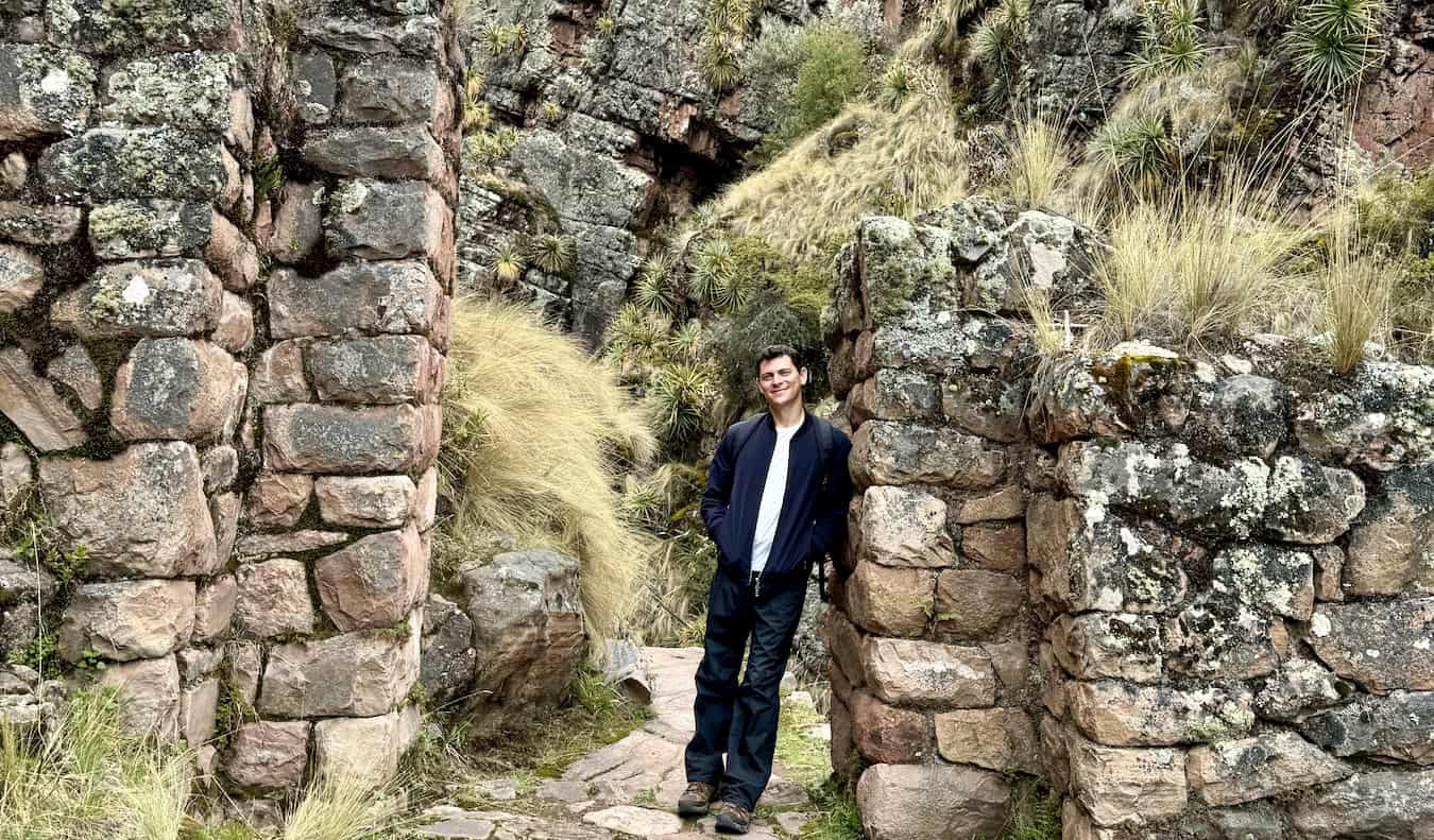 Nomadic Matt posing near old Inca ruins while hiking in Peru