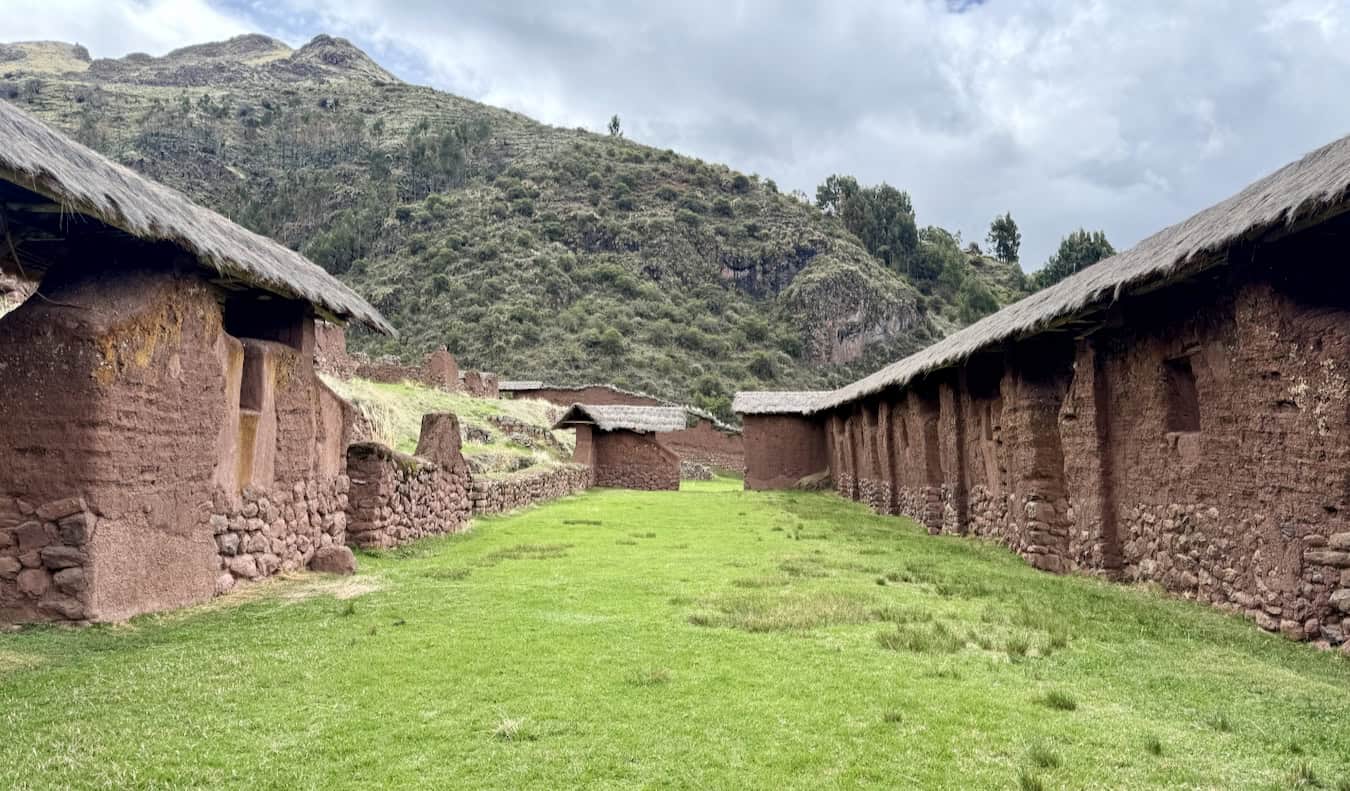 Old ruins from the Inca in Huchuy Qosqo, Peru with towering hills in the background