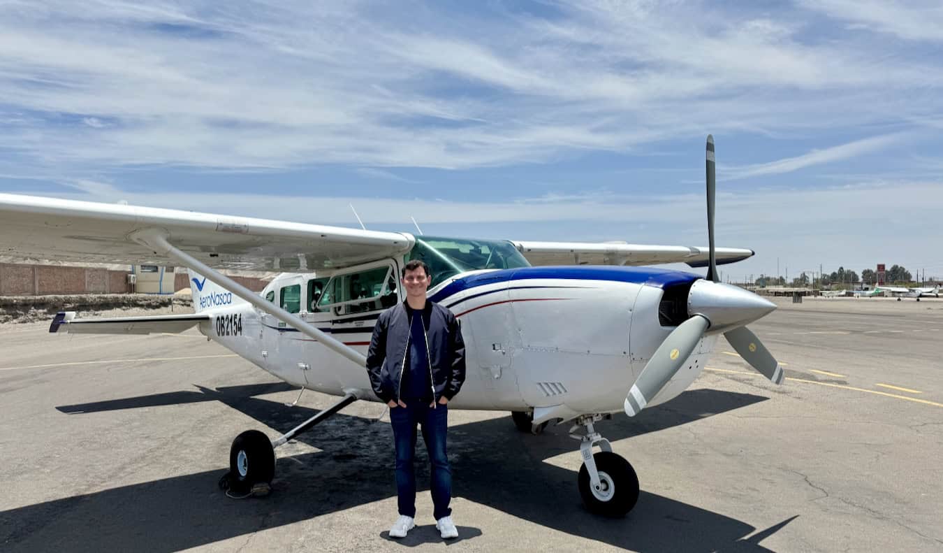 Nomadic Matt poses near a small plane while traveling in Peru