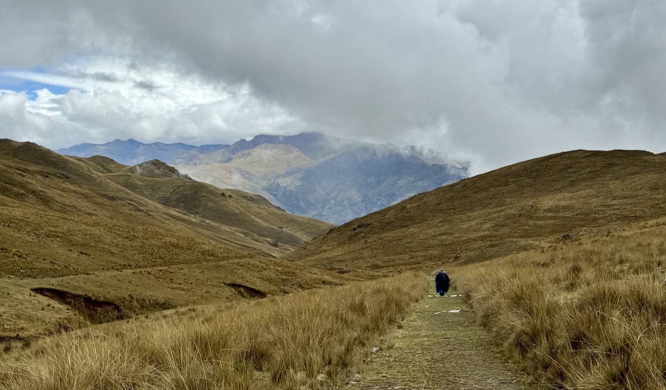 An old woman hiking in the distance in the Sacred Valley of Peru