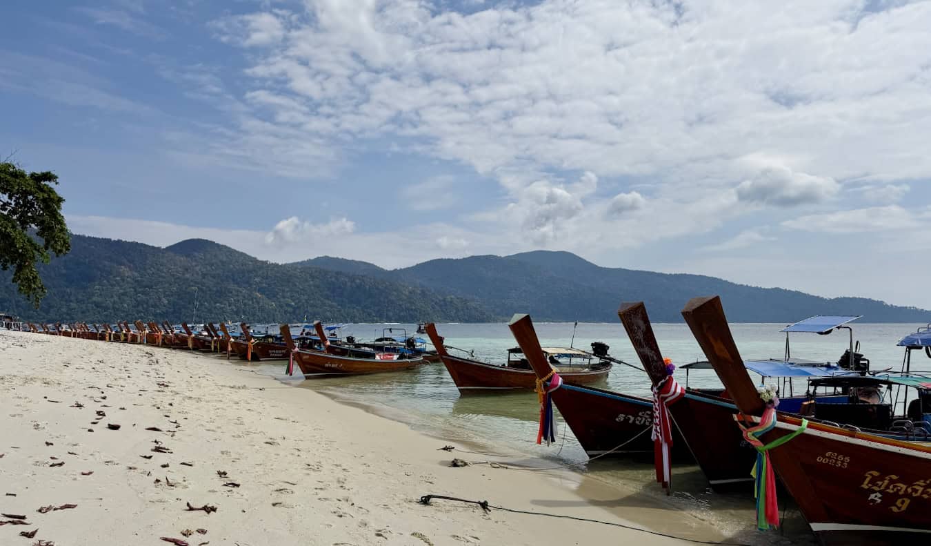 lots of longtail boats lining the beaches near the island of Ko Lipe in Thailand