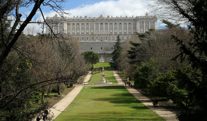 the royal palace in Madrid, Spain with a long, narrow lawn on a sunny day