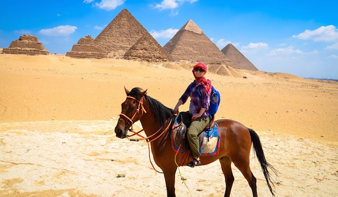 Woman nomad riding a horse at the Pyramids in Egypt