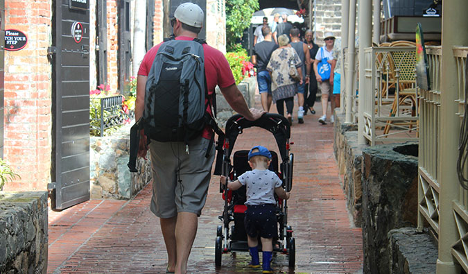 A dad and son walking down a narrow alley together