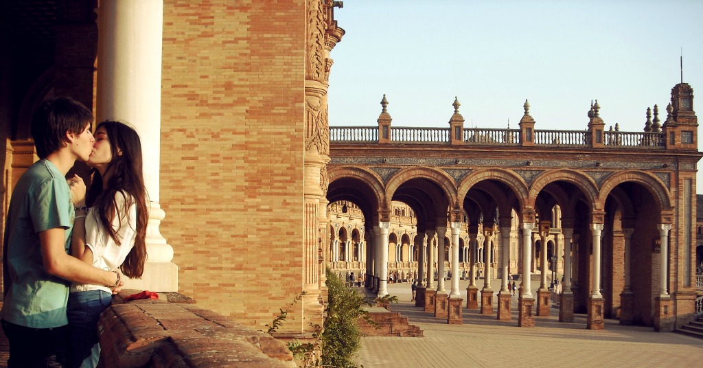 backpacking couple kissing near architecture in Europe on vacation