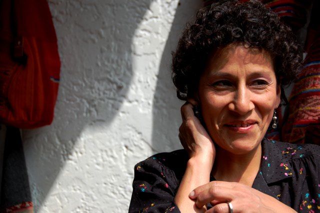 A woman with curly hair posing for a photo abroad