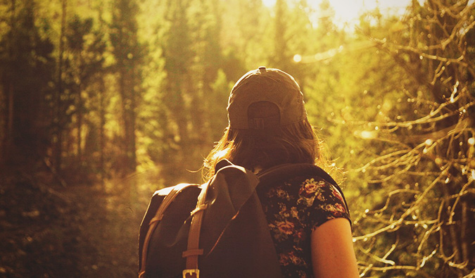 A solo female traveler hiking in the woods