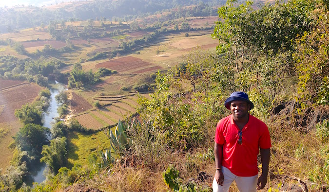 Alex, a solo male traveler, in front of rice paddy fields in Southeast Asia