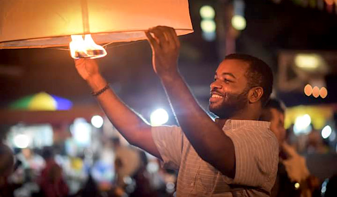 Alex, a black male traveler, at the lantern festival in Southeast Asia
