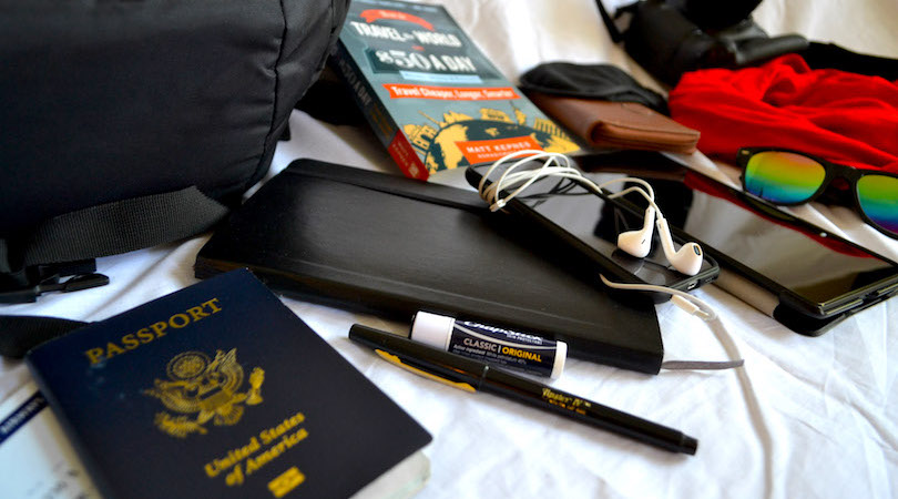 Nomadic Matt's gear on the bed as he packs his backpack before a trip