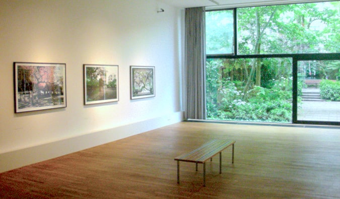 Minimal gallery room with framed photographs on the wall and a bench to sit on at FOAM photography museum in Amsterdam