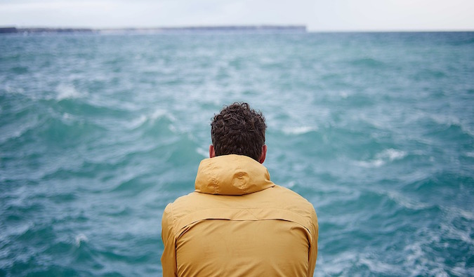 A man looking out looking for the water on a rainy day