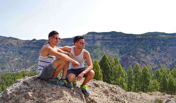 auston and david from two bad tourists posing ona  cliff while hiking