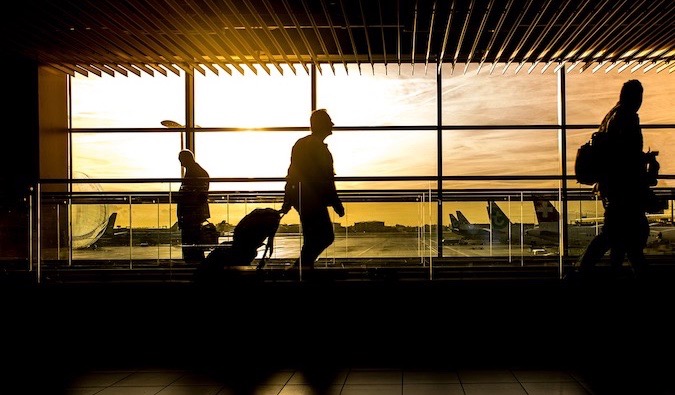 A man walking through an airport pulling his luggage