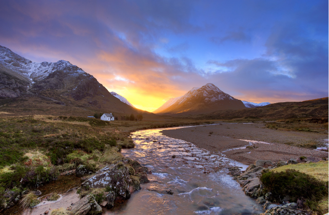 Photograph of a river and mountain and a colorful sunset