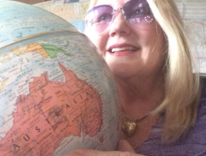 Diane, an older Canadian traveler, who is holding a colorful globe