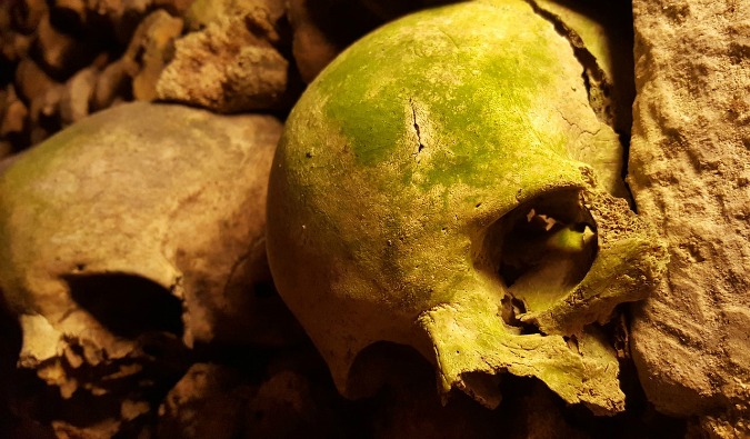 Cracked skulls in the dark, eerie Paris catacombs underneath the city