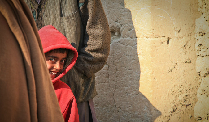 A shy young boy hiding from the camera