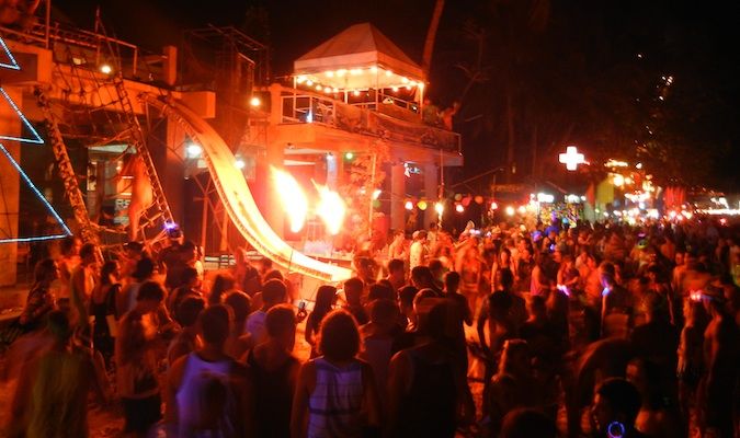 Crazy fire sign and young backpacking tourist crowds in Thailand at the Full Moon Party