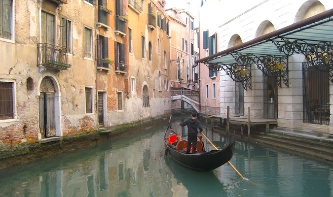 Gorgeous gondola with tourists in the canals of venice, Italy