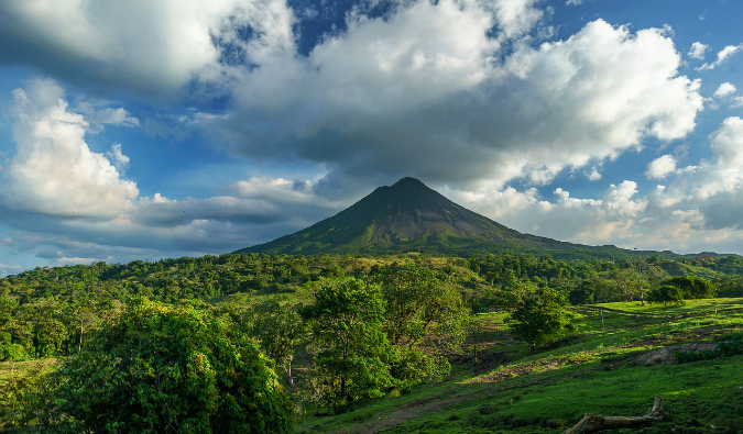 A lone volcano in the distance overlooking a lush jungle