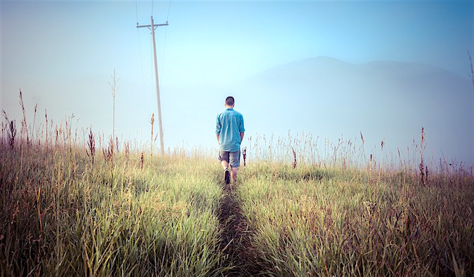 A lone man walking through an empty field