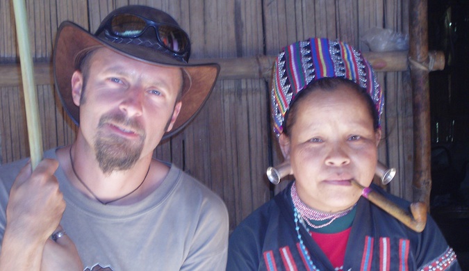 Dan Slater posing for a photo in Asia with a local woman