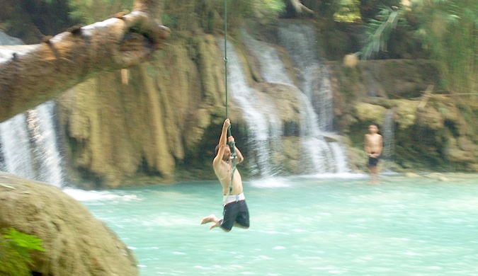 dan slater swinging on a rope into water in Asia