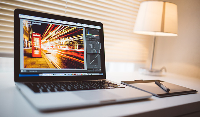 A laptop editing a long-exposure photo while sitting on a desk in an office