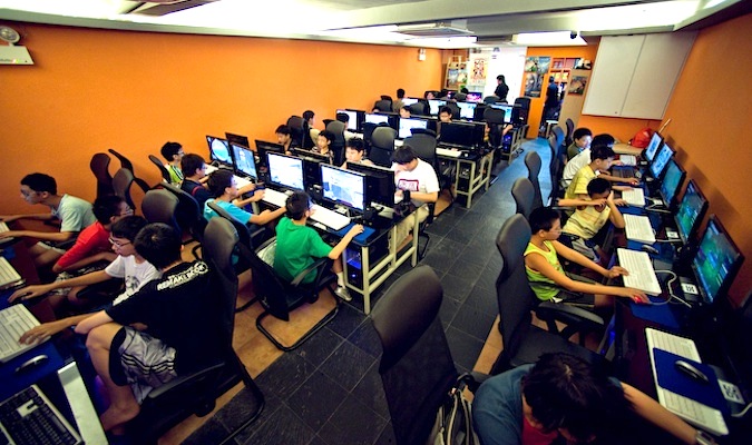 A public computer cafe bustling with people using the computers