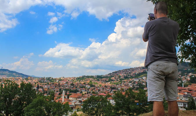 Dave takes a photo from the top of a mountain overseas while traveling