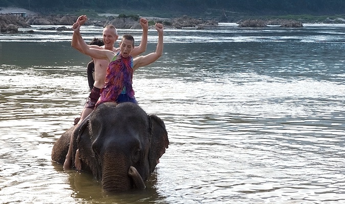 Don and Alison, a happy senior couple traveling the world posing with an elephant