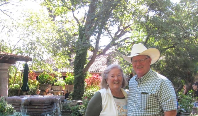 A retired couple posing for a photo while traveling abroad