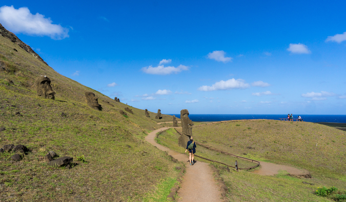 Kristin Addis posing in from of the stone heads on Easter Island, South America