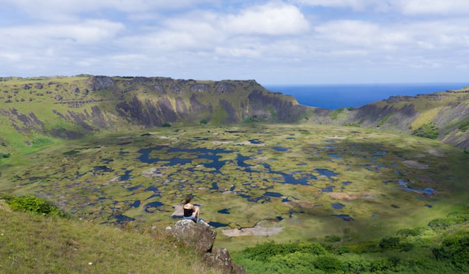 viajero sentado y mirando el paisaje prístino de la Isla de Pascua