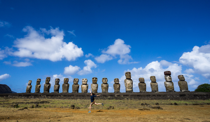 Uma mulher a dançar numa pedreira onde as estátuas foram esculpidas e o museu em Rano Kau, Ilha de Páscoa