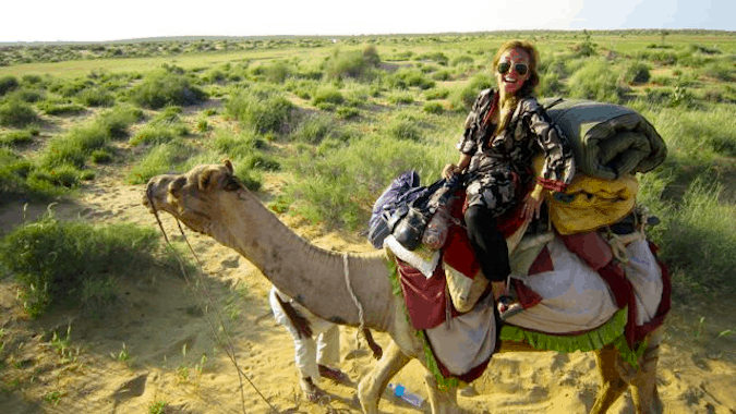 A solo female traveler riding a camel