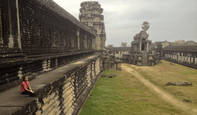 A solo female posing on the stones at Angkor Wat in Cambodia