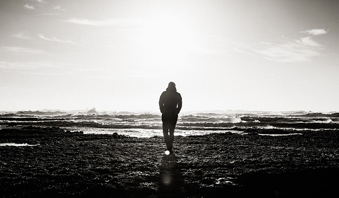 black and white image of a man staring out to sea