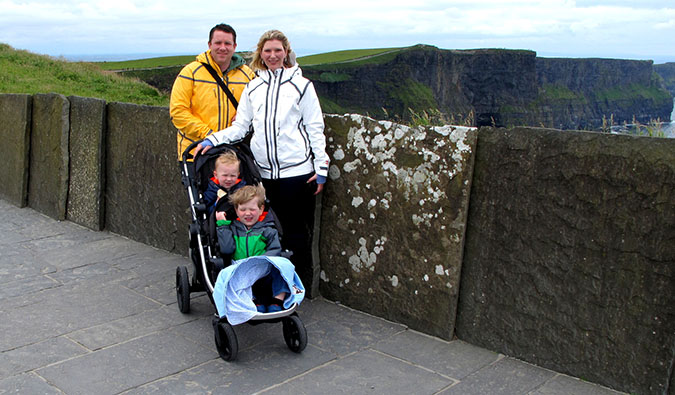 Cameron and Nicole Wears posing with their children on the windy coast of Ireland