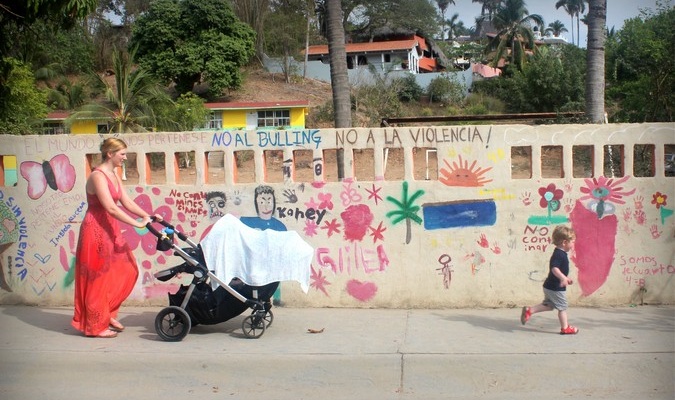 A mom walking around in South America with her toddler and baby stroller