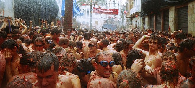 Hundreds of people covered in tomatoes at the La Tomatina tomato-throwing festival in Spain